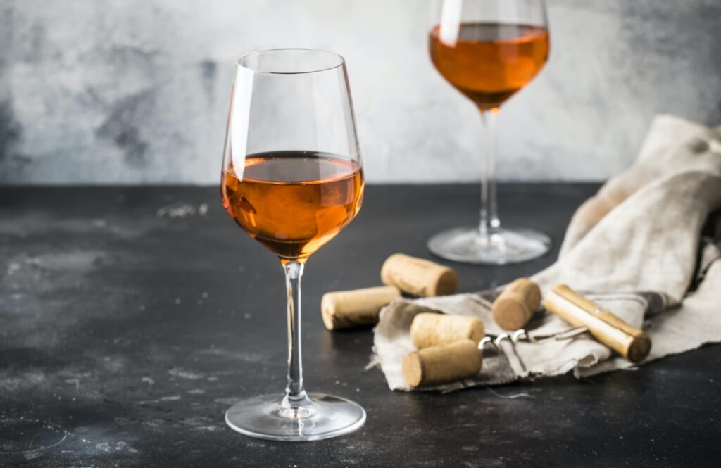 Orange wine in big wine glass, fashionable modern drink